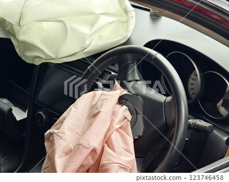 Airbag is currently hanging from the steering wheel of a car Airbag is currently hanging from the steering wheel of a car 123746458
