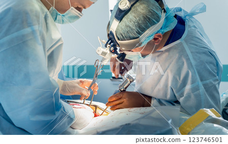 Spinal surgery. Group of surgeons in operating room with surgery equipment.  123746501