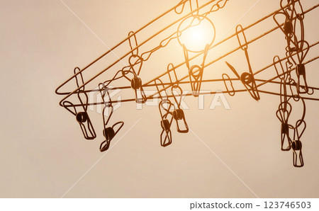 Silhouette of colorful clothespins is hanging on a clothesline 123746503