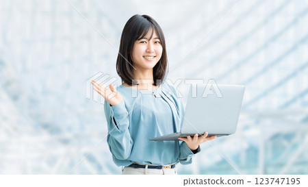 A smiling woman/businesswoman giving directions while holding a laptop 123747195