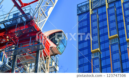 Crane on the construction site in a site surrounded by the high buildings. 123747306