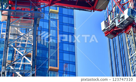 Crane on the construction site in a site surrounded by the high buildings. 123747310