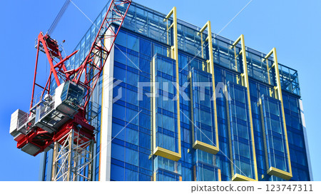 Crane on the construction site in a site surrounded by the high buildings. Crane on the construction site in a site surrounded by the high buildings. 123747311