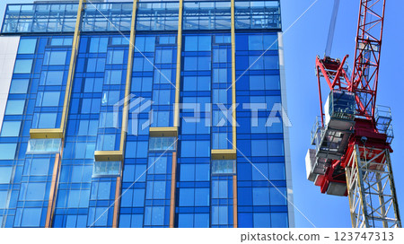 Crane on the construction site in a site surrounded by the high buildings. Crane on the construction site in a site surrounded by the high buildings. 123747313