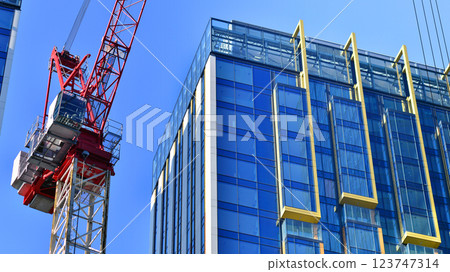 Crane on the construction site in a site surrounded by the high buildings. Crane on the construction site in a site surrounded by the high buildings. 123747314