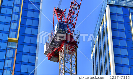 Crane on the construction site in a site surrounded by the high buildings. Crane on the construction site in a site surrounded by the high buildings. 123747315