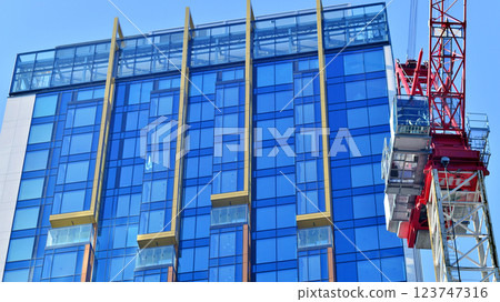 Crane on the construction site in a site surrounded by the high buildings. Crane on the construction site in a site surrounded by the high buildings. 123747316