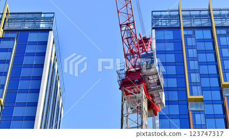 Crane on the construction site in a site surrounded by the high buildings. Crane on the construction site in a site surrounded by the high buildings. 123747317