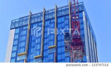 Crane on the construction site in a site surrounded by the high buildings. Crane on the construction site in a site surrounded by the high buildings. 123747318