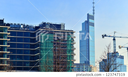 Crane on the construction site in a site surrounded by the high buildings. Crane on the construction site in a site surrounded by the high buildings. 123747319