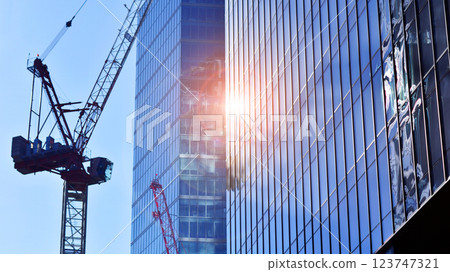 Crane on the construction site in a site surrounded by the high buildings. 123747321