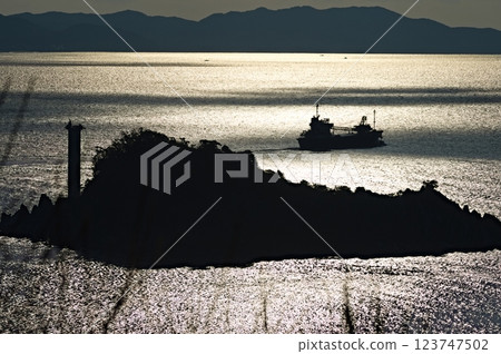 Naruto Strait and a small fishing boat bathed in the morning sun Naruto Strait and a small fishing boat bathed in the morning sun 123747502