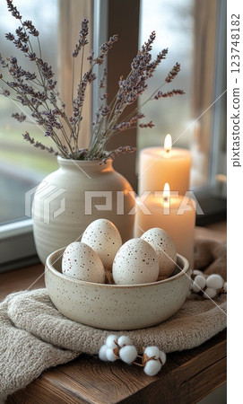Decorative arrangement of speckled eggs, candles, and lavender in a cozy indoor setting during a calm afternoon 123748182