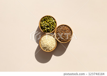 Organic Superfood Trio. Pumpkin Seeds, Flax, Sesame in Rustic Wooden Bowls. Organic Superfood Trio. Pumpkin Seeds, Flax, Sesame in Rustic Wooden Bowls. 123748184