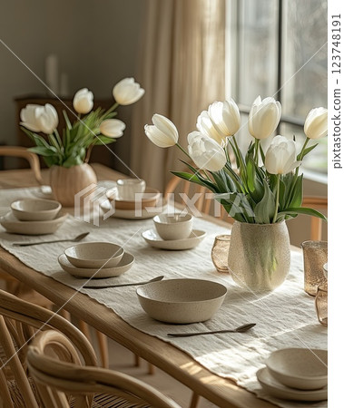 Elegant dining table with white tulips and minimalist settings in a sunlit room Elegant dining table with white tulips and minimalist settings in a sunlit room 123748191