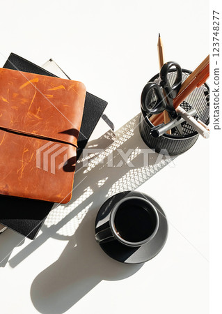 Pile of Books and Cup of Espresso Arranged on White Desk. Pile of Books and Cup of Espresso Arranged on White Desk. 123748277