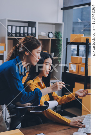 Asian SME business women use laptop computer checking customer order online shipping boxes at home. Starting Small business entrepreneur SME freelance. Online business, Work at home concept. 123748364