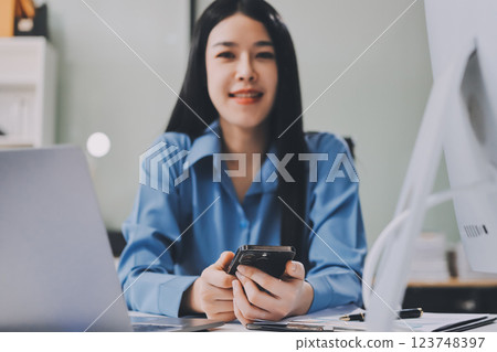 Entrepreneur Asian businessman and businesswoman discussing new business project in tablet in modern Meeting In Modern Office, Asian business casual concept. 123748397