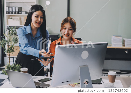 Entrepreneur Asian businessman and businesswoman discussing new business project in tablet in modern Meeting In Modern Office, Asian business casual concept. 123748402
