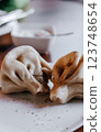Indulge in the Most Delicious Dumplings Served on a Plate Accompanied by a Flavorful Dip 123748654