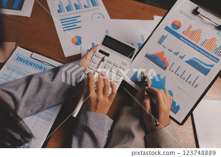 Group of confident business people point to graphs and charts to analyze market data, balance sheet, account, net profit to plan new sales strategies to increase production capacity. Group of confident business people point to graphs and charts to analyze market data, balance sheet, account, net profit to plan new sales strategies to increase production capacity. 123748889