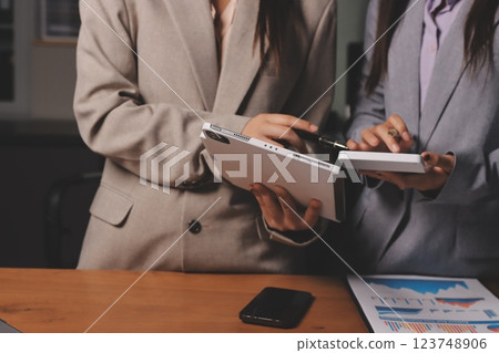 Group of confident business people point to graphs and charts to analyze market data, balance sheet, account, net profit to plan new sales strategies to increase production capacity. 123748906