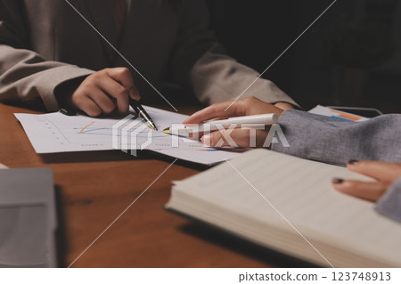 Group of confident business people point to graphs and charts to analyze market data, balance sheet, account, net profit to plan new sales strategies to increase production capacity. Group of confident business people point to graphs and charts to analyze market data, balance sheet, account, net profit to plan new sales strategies to increase production capacity. 123748913