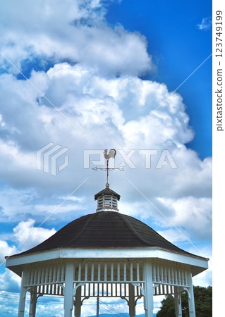 A weather vane and a white gazebo against the blue sky 123749199