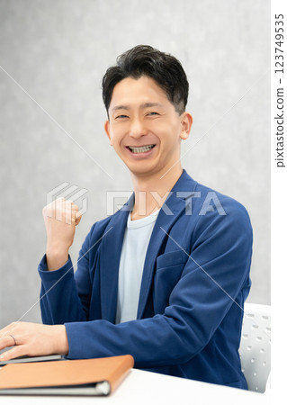 Smiling male businessman doing a fist pump Smiling male businessman doing a fist pump 123749535