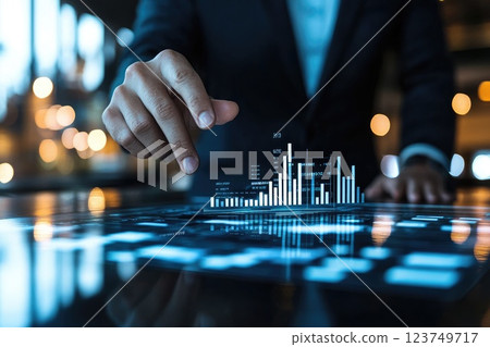A man is pointing at a graph on a computer screen A man is pointing at a graph on a computer screen 123749717