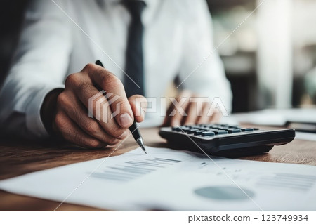Businessman Calculating Expenses with Calculator Businessman Calculating Expenses with Calculator 123749934