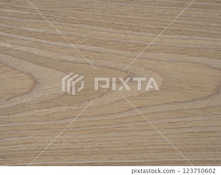 Swirling patterns of ash wood veneer dance in a delicate fusion of tan, wheat, and honeyed tones 123750602