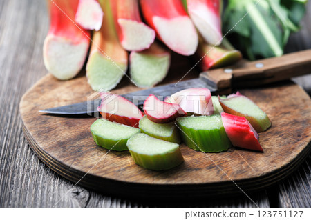 Cutting ripe rhubarb stalks on a wooden cutting board 123751127