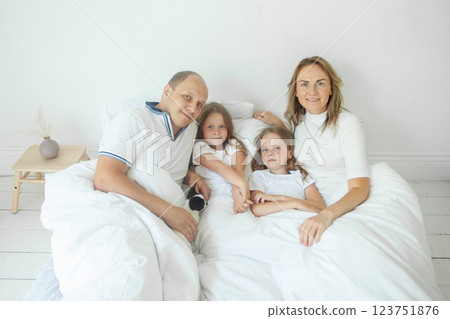 Cute mother, father and girls at home. Happy family 123751876