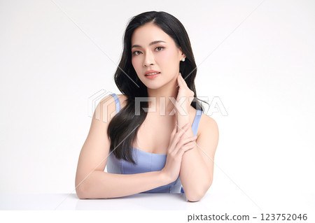 A beautiful young Asian woman with clean, fresh skin against a white background. She represents beauty, skincare, and spa treatments. 123752046