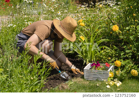 Man in a straw hat is working in the garden. 123752160