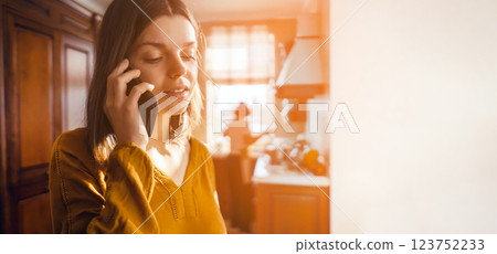 Girl talks on the phone in her cozy house. Girl talks on the phone in her cozy house. 123752233