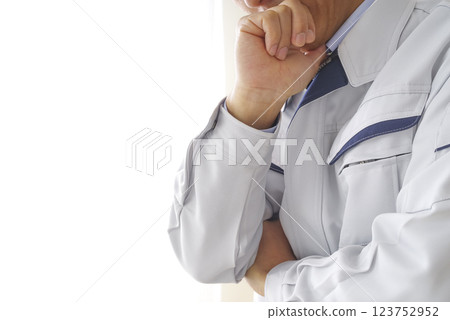 A man in work clothes thinking 123752952