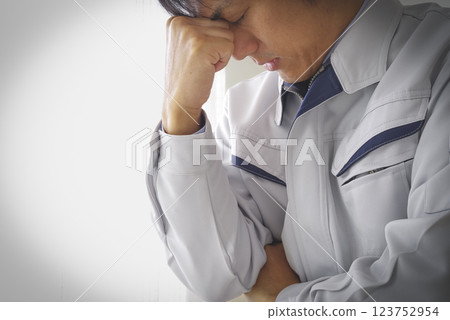 A man in work clothes thinking 123752954