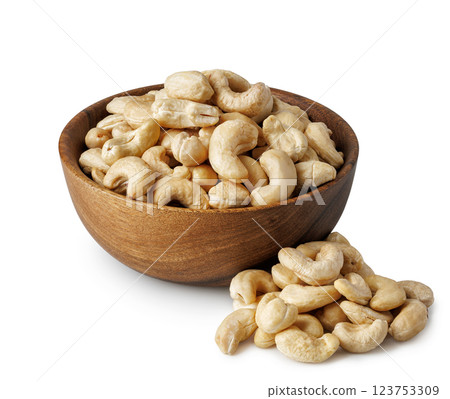 Cashew nuts in wooden bowl and pile nearby isolated on white background 123753309