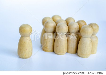 A wooden figure representing a leader who is directing other wooden figures. Leadership concept 123753987