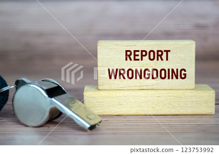 Report Wrongdoing text on wooden blocks with whistle. Whistleblow concept Report Wrongdoing text on wooden blocks with whistle. Whistleblow concept 123753992