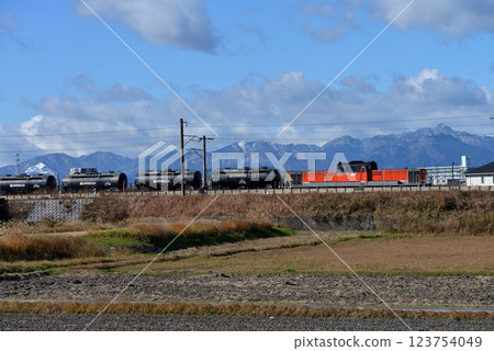 DD511801 cement freight train running with the Suzuka Mountains in the background 123754049