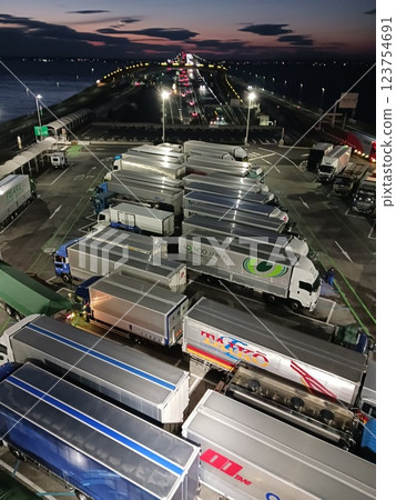 A flock of trucks gathering at a parking area at night - a logistics hub on the highway A flock of trucks gathering at a parking area at night - a logistics hub on the highway 123754691