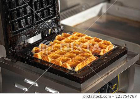 Cooking belgian waffles in the cafe kitchen Cooking belgian waffles in the cafe kitchen 123754767