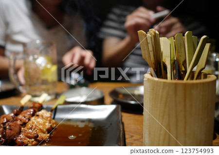 Eating yakitori and having drinks with friends Eating yakitori and having drinks with friends 123754993