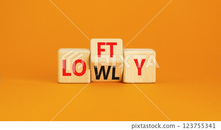 Lofty or lowly symbol. Concept words Lofty Lowly on wooden block. Beautiful orange table orange background. Business lofty or lowly concept. Copy space. 123755341