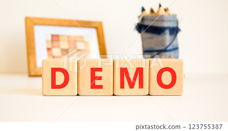 Demo symbol. Concept word Demo on beautiful wooden blocks. Beautiful picture frame and colored pencils. Beautiful white table white background. Business and demo concept. Copy space. 123755387