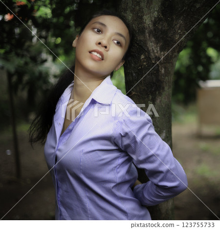 Indonesian girl posing by a tree 123755733