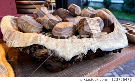 close-up of a rustic wooden bowl filled with handcrafted geometric wooden decorations. The bowl features intricate natural wood grain and textured edges, showcasing exceptional artisanal craftsmanship close-up of a rustic wooden bowl filled with handcrafted geometric wooden decorations. The bowl features intricate natural wood grain and textured edges, showcasing exceptional artisanal craftsmanship 123756476